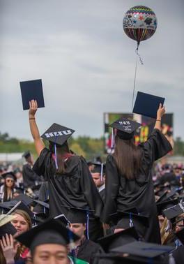 毕业生们在毕业典礼上挥舞着毕业帽