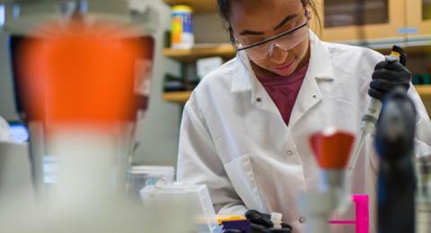 Female UNH student working in science lab